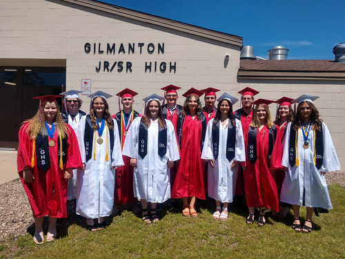 Class of 2024 in caps and gowns outside the high school.