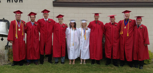 Class of 2015 standing outside the MS/HS building in their caps & gowns